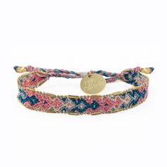 the multicolored braid bracelet is shown with a gold plated charm on it