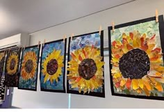 four sunflowers are hanging on the wall next to each other