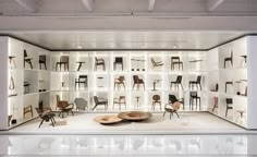 a room filled with lots of chairs and shelves full of different types of furniture on display