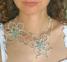 a woman wearing a necklace with flowers on it