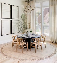 the dining room table is surrounded by chairs and pictures on the wall, along with a chandelier