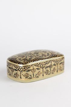 an ornately decorated gold box on a white background