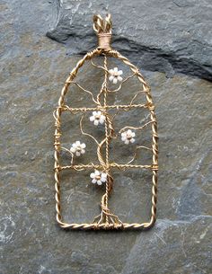 a wire and glass birdcage with flowers on it sitting on top of a rock