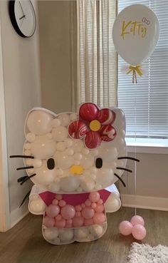 a hello kitty balloon and some balloons in a room