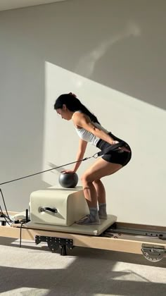 a woman is doing exercises on a rowing machine