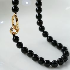 Material: black agate + copper plated 18K goldReplace the previously used white pearls with black onyx beading for a mysterious, gender-neutral appearance. Black is the epitome of timelessness, creating a classic fashion piece. Equipped with a few metal latches, this piece can be worn as a necklace, glasses chain, bracelet, or more. Men can use it as part of their outfit for a fashionable, unisex style. This accessory can be worn alone or stacked to achieve a low-key, stable, and elegant look. Minimalist 8mm Onyx Bead Jewelry, Elegant Single Strand Onyx Jewelry, Formal Black Necklaces With Natural Stones, Luxury Black Necklace With Polished Beads, Formal Onyx Jewelry With Black Beads, Elegant Onyx Necklace With Polished Beads, Onyx Gemstone Beads Necklace, Elegant Black Onyx Beaded Necklace, Elegant Black Round Beads Jewelry