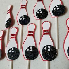 a number of bowling pins on a table with glittered pins in the shape of skittles