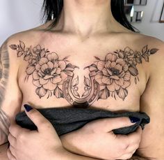 a woman with tattoos on her chest holding a black towel in front of her stomach