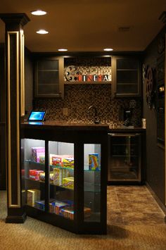 a kitchen with a laptop on the counter and shelves full of food in it's display case