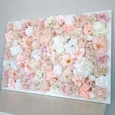 a white and pink flowered wall hanging on the wall