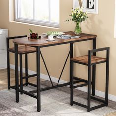 a table with two stools in front of it and a vase on the side