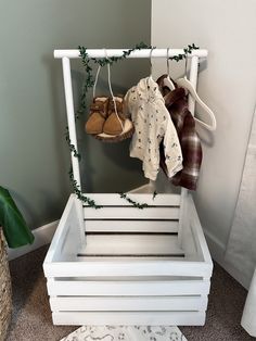 a white wooden crate with clothes hanging on it