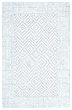 a white rug with an intricate design on the front and back side, in shades of blue