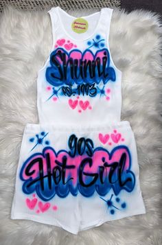 Designs by Galveston Airbrush! ♡ ✧ Our Designs on these cute White beater Tank tops and Booty Shorts are handmade with the artists' skilled Hands.  ✧The Design might look slightly different from the pictures or have small imperfections and that's okay, it's what makes them unique Each design includes up to TWO names or words with up to THREE specified COLORS. DESIGN PLACEMENT: All designs are airbrushed on the FRONT of our White Beater Tank top and BACK of the Booty Shorts unless specified other Blue Sets For Summer Streetwear, Blue Summer Streetwear Sets, Summer Graffiti Print Bottoms, White Graphic Print Bottoms For Beach Season, Trendy Cotton Short Set, Pink Graphic Print Shorts For Summer, White Beach Season Shorts For Streetwear, Fitted Graphic Print Shorts For Summer, Trendy Summer Sets With Graphic Print