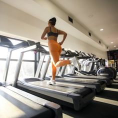 a woman running on a treadmill in a gym