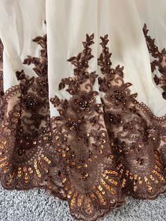 an image of a lace curtain with gold sequins on the bottom and sides