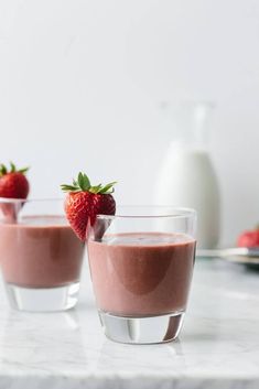 two glasses filled with chocolate pudding and strawberries