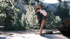 a person doing a handstand in front of some trees