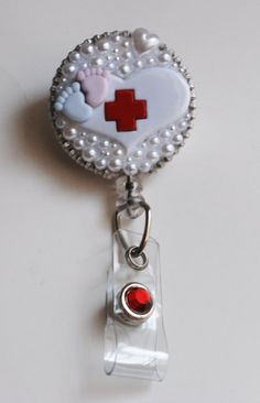 a badge with a red cross in the center and pearls around it on a white surface