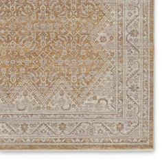 a beige and gold rug with an intricate design on the bottom, in front of a white background