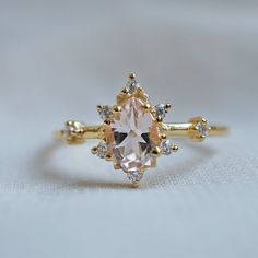 This ring is an elegant beauty for the ages. A peachy morganite set in sterling silver with 14K plated yellow gold. Definitely a timeless classic. Pair it with our ring bands to create the ultimate royal stack. Available in yellow gold vermeil, rose gold, and silver, or 14k solid gold. For natural diamonds, options click here. Gold vermeil or 14k solid gold 7x5mm natural morganite Round CZs (what's this?) ** This item is specially made for you. Please allow 1-2 week lead time. ShippingDomestic: Rose Gold Rings With Diamond Accents And Morganite, Elegant Pink Gold Morganite Rings, Elegant Morganite Rings With Diamond Accents, Rose Gold Topaz Ring With Morganite And Accent Stones, Elegant Topaz Ring With Morganite In Prong Setting, Timeless Gold Cluster Ring With Gemstone, Timeless Morganite Rose Gold Jewelry, Rose Gold Morganite Ring With Center Stone, Timeless Rose Gold Morganite Jewelry