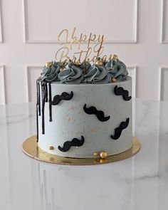 a birthday cake decorated with black and gold mustaches