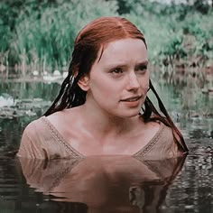 a woman with red hair is in the water