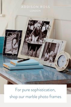 a table topped with pictures and books next to a clock on top of it's side