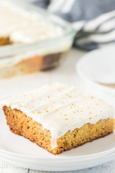 a piece of cake sitting on top of a white plate next to a glass dish