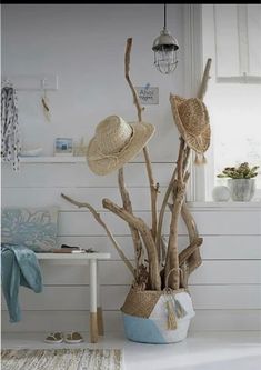 a white room with some hats on top of the branches and a rug in front of it