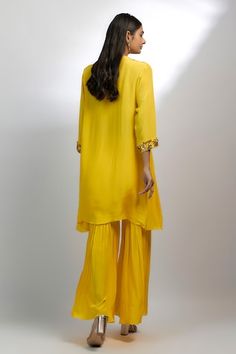 Sunflower yellow A-line kurta featuring hand embroidery with beads, stones, and pearls on the yoke. Paired with a coordinating gharara that complements the kurta's design., Fit: Relaxed Festive Yellow Hand Embellished Set, Festive Hand Embellished Yellow Set, Yellow Palazzo Set With Mirror Work For Eid, Elegant Yellow Palazzo Set With Mirror Work, Yellow Festive V-neck Sets, Festive Yellow V-neck Set, Embellished Yellow Sharara For Eid, Yellow Embellished Designer Wear Sets, Designer Yellow Embellished Sets