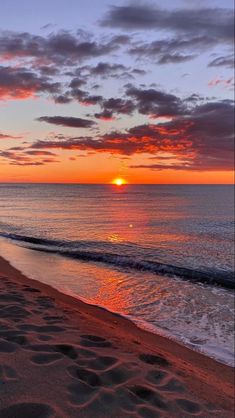 the sun is setting over the ocean and beach