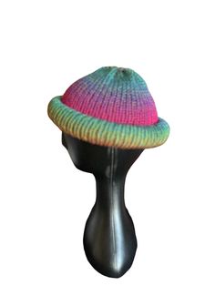 a multicolored knitted hat sitting on top of a mannequin head