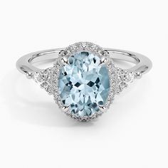 an oval blue topazte and diamond ring with two rows of diamonds around it