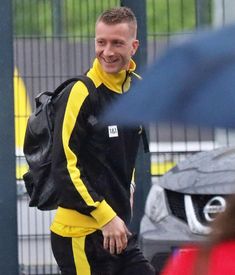 a man in black and yellow is walking