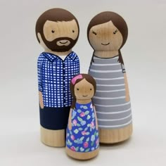 two wooden dolls are standing next to each other