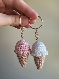 two crocheted ice cream cones are being held by a hand