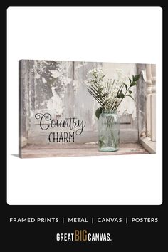 a vase filled with flowers sitting on top of a window sill next to a sign that says country charm