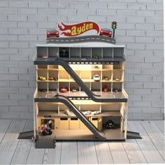 a toy car garage with stairs and cars on the top floor in front of a brick wall