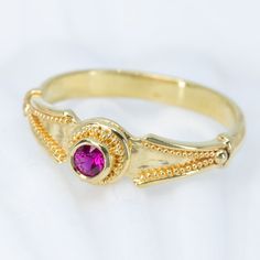 This 18K granulated gold ring adds a classic touch to any ensemble. A simple and elegant design combined with a timeless look make this Ruby Classical Ring the perfect accessory for a variety of occasions. 18K gold granulated ring with beautiful 0.22ct ruby. Currently a size 8, but each ring comes with free sizing and FREE SHIPPING! Unsure what ring size you are? It's always best to be sized by a professional jeweler, but if that is not available, you can use our special Ring Sizing Chart. Elegant 22k Gold Rings With Bezel Setting, Elegant Gold Ruby Ring With Stone Setting, Formal Gold Stackable Ruby Rings, Elegant 22k Gold Ruby Ring, Gold Ruby Ring With Accent Stones, Classic Yellow Gold Rings With Stone Setting, 22k Yellow Gold Ruby Ring For Anniversary, 22k Gold Ruby Ring For Anniversary, Classic Gold Stackable Rings With Accent Stones