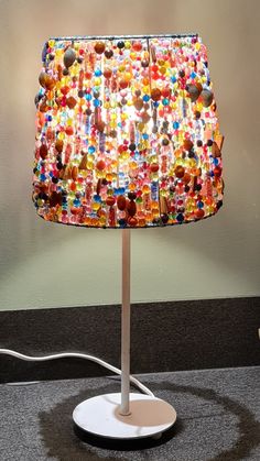 a lamp that is sitting on top of a table next to a light fixture with buttons all over it