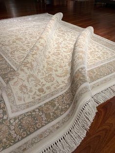 a large white rug on top of a wooden floor