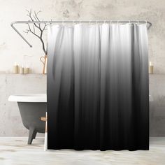 a black and white shower curtain hanging in front of a bathtub next to a toilet