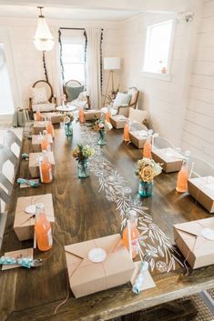 a wooden table topped with lots of boxes filled with flowers and candles on top of it