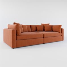 an orange couch with many pillows on it's back and sides, in front of a white background