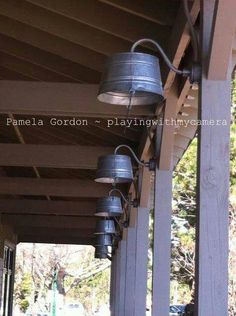 some lights are hanging on the side of a building with trees in the back ground