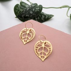 A beautiful & unique pair of Anthurium Clarinervium inspired gold hoop earrings, created based upon my original illustration Also available as statement drop earrings & a necklace ▲ DETAILS ▲ These lightweight earrings measure 4.5cm and the hoop measures 1.5cm The leaf part is made from laser cut nickel free brass plated with a lovely matt gold finish and the hoop is made from high quality hypoallergenic nickel free brass All metal findings are nickel free and hypoallergenic ▲ CARE ▲ All of the Gold Leaf-shaped Hoop Earrings For Gift, Nature-inspired Gold Hoop Earrings, Nature-inspired Gold Hoop Earrings For Pierced Ears, Gold Nature-inspired Hoop Earrings, Handmade Gold Hoop Earrings Nature-inspired, Handmade Gold Nature-inspired Hoop Earrings, Handmade Gold Hoop Earrings With Nature-inspired Style, Gold Handmade Nature-inspired Hoop Earrings, Gold Leaf Hoop Earrings