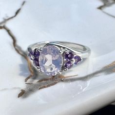 The Laura Ring is elegant for both everyday where and special occasions.  1 - 8x6mm Lavender Moon Quartz 6 - 2.5mm Amethyst Sterling Silver  10% of proceeds will be donated to benefit CAST LA to combat human trafficking. Oval Amethyst Ring With Gemstone Accents In Sterling Silver, Lavender Amethyst Ring In Oval Sterling Silver, Lavender Amethyst Ring In Sterling Silver, Lavender Oval Amethyst Ring In Sterling Silver, Oval Amethyst Crystal Ring With Accent Stones, Lavender Amethyst Ring With Accent Stones, Amethyst Crystal Ring With Accent Stones, Lavender Oval Rings With Accent Stones, Amethyst Oval Cabochon Ring For Anniversary