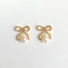 Decorate yourself with these classic Bow Earring beauties with two freshwater pearl drops available in a shimmery golden 18CT Gold Plating or a Sterling Silver option. Inspired by a love of Victorian bygone jewels, these earrings are a playful nod towards popular motifs used, it's all about the dangle, brining a little glamour to your ears to be enjoyed on any occasion. All posts are made from sterling silver and coated in 18CT Gold to protect sensitive ears  All pieces are handmade to order ple Earrings With Pearls, Preppy Jewelry, Smink Inspiration, Wire Jewellery, Jewelry Accessories Ideas, Dope Jewelry, Classy Jewelry, Jewelry Essentials, Bow Earrings