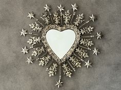 a heart shaped mirror with many stars around it